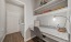 a white kitchen with a white countertop and a white door