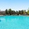 a swimming pool with trees and buildings in the background